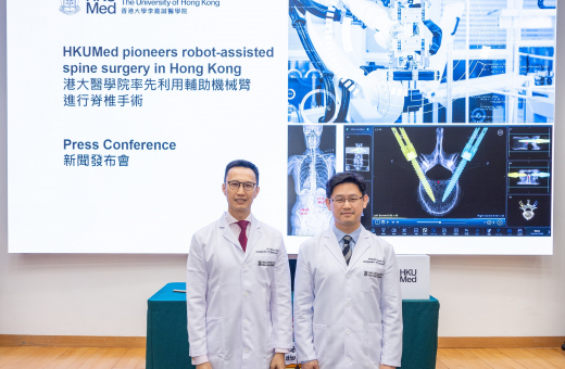 由鍾培言教授（右）及關日康醫生領導的港大醫學院科研團隊，介紹首次在本港使用輔助機械臂進行脊椎手術的情況